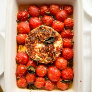 This easy to make gluten-free baked feta dip is ready in just 25 minutes. It is perfect when company comes over or to bring to your next holiday party. It uses simple ingredients like feta, baby tomatoes, chili oil, and basil. So easy to make and oh so delicious.