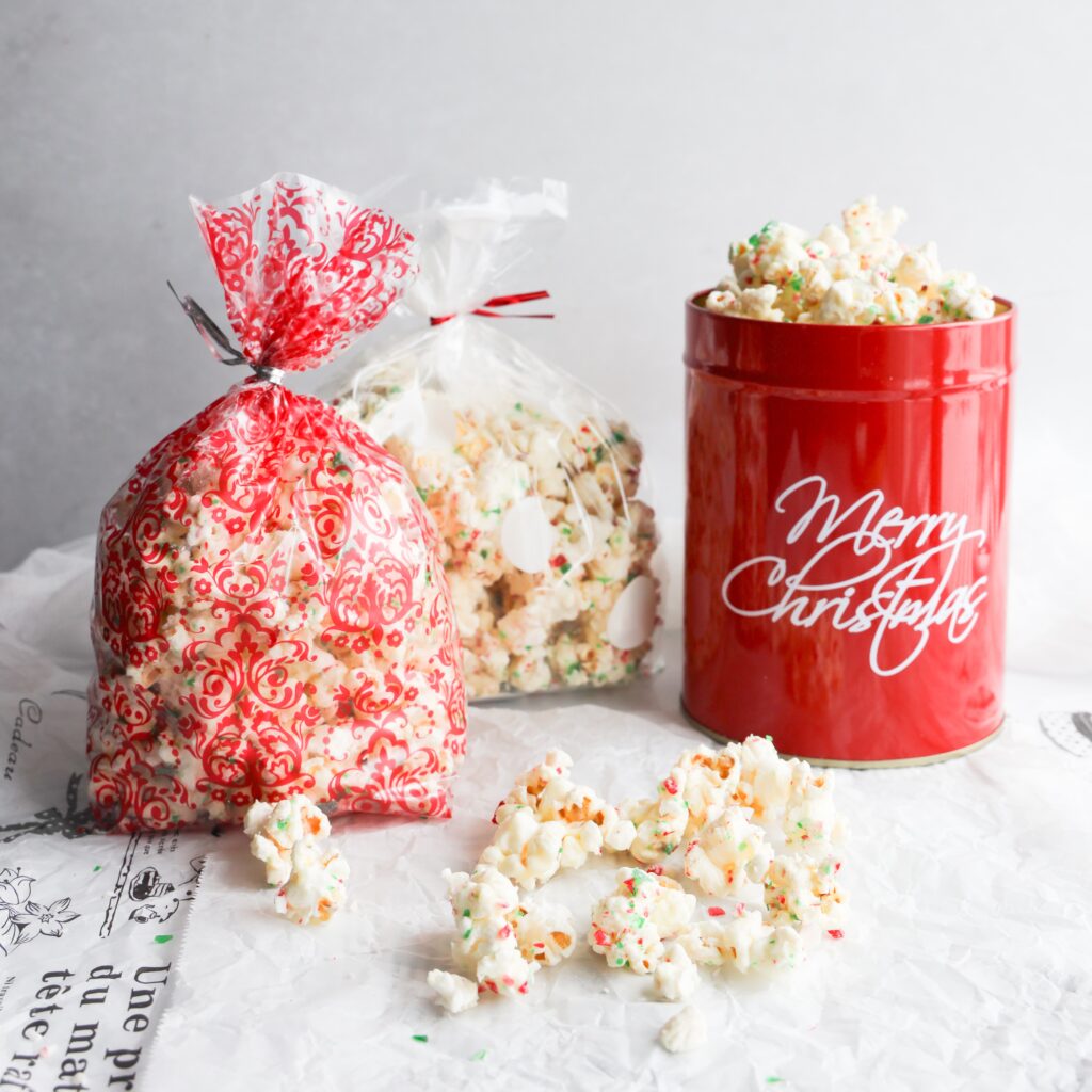 This white chocolate peppermint popcorn is easy to make, delicious and the perfect gluten-free treat for the holidays. Only 3 ingredients needed, melted white chocolate and crushed gluten-free candy canes is poured over lightly salted popcorn and mixed. Perfect for holiday parties, food gifts or snacking at home while watching Christmas movies.