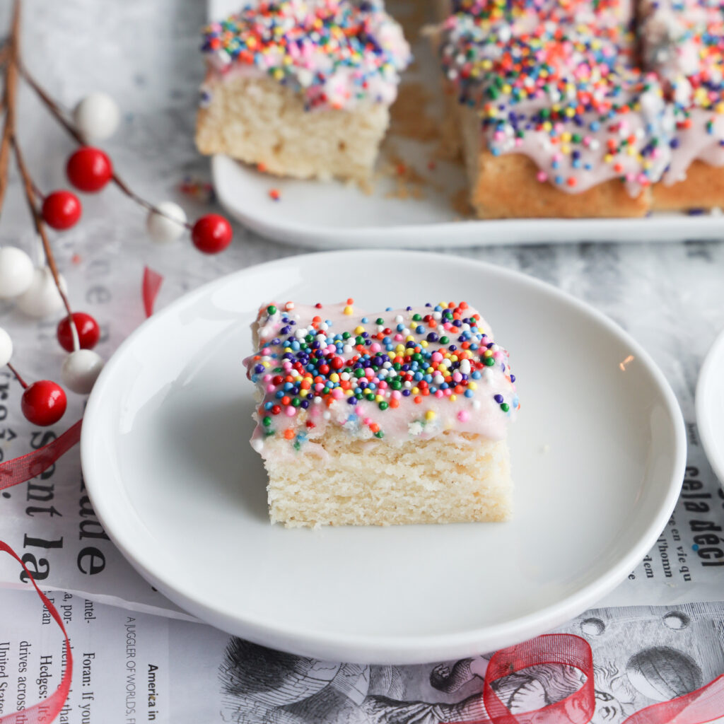 Indulge in holiday baking with these gluten-free sugar cookie bars that are topped with a creamy pink frosting and sprinkles. An easy to make, delicious sweet treat that is perfect for any occasion. The same great taste of a sugar cookie without the chilling, rolling and cutting out of shapes.